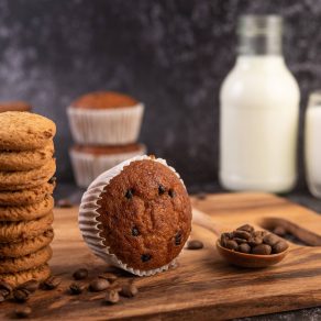 Banana cupcakes that are placed on a wooden plate with coffee grains. Selelctive focus.